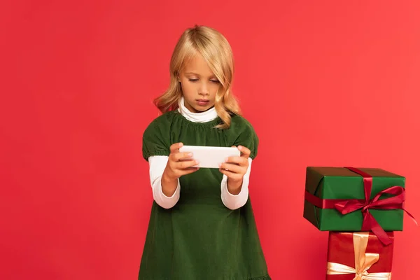 Κορίτσι Πράσινο Φόρεμα Χρησιμοποιώντας Smartphone Κοντά Κουτιά Δώρων Που Απομονώνονται — Φωτογραφία Αρχείου