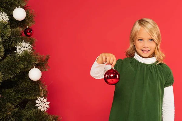 Child Green Dress Showing Shiny Christmas Ball Decorated Spruce Isolated — Stock Photo, Image