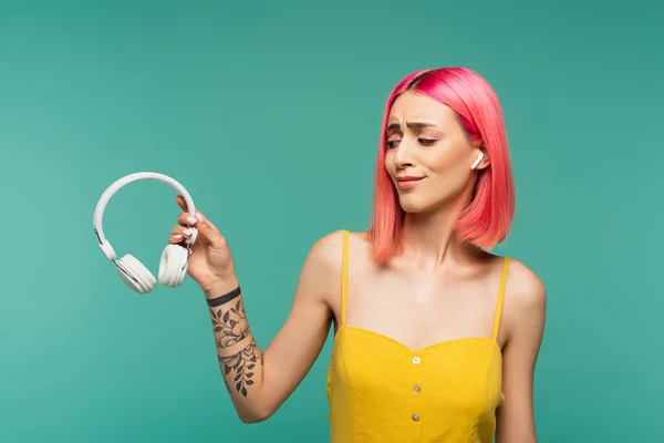 Skeptical Young Woman Earphone Holding Wireless Headphones Isolated Blue — Stock Photo, Image