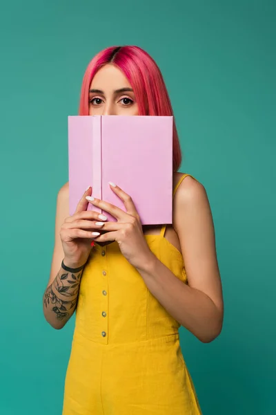 Молодая Женщина Розовыми Окрашенными Волосами Держит Книгу Скрывая Лицо Изолированы — стоковое фото