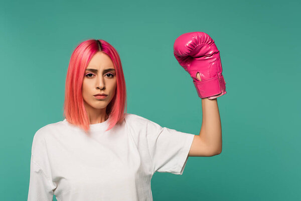 young woman with pink dyed hair in boxing glove isolated on blue