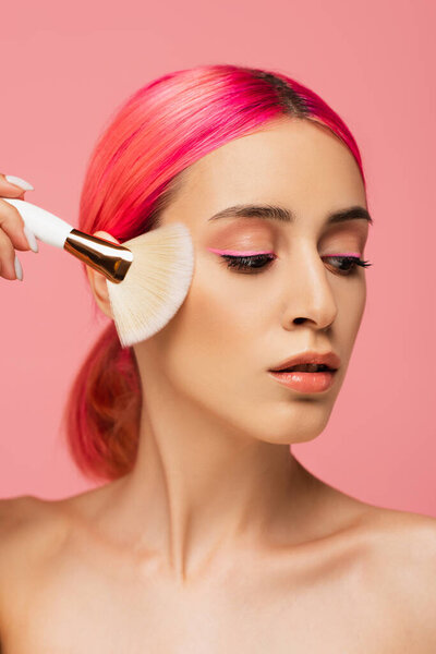 pretty young woman with colorful hair holding cosmetic brush isolated on pink 