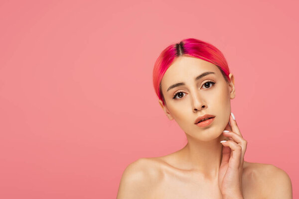 pretty young woman with colorful hair and bare shoulders touching perfect skin isolated on pink 