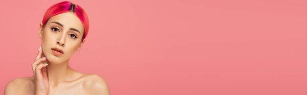 pretty young woman with colorful hair and makeup looking at camera isolated on pink, banner