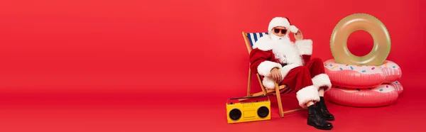 Güneş Gözlüklü Noel Baba Güvertedeki Sandalyede Klasik Müzik Kutusunun Yanında — Stok fotoğraf