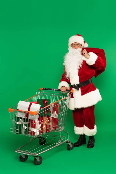 Papai Noel Com Saco Perto Carrinho Compras Com Presentes Fundo — Fotografia de Stock