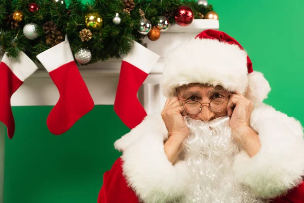 Rozrušený Santa Claus Při Pohledu Kameru Blízkosti Zdobeného Krbu Zeleném — Stock fotografie