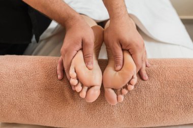 Masörün kaplıcadaki kadına ayak masajı yaptığı görüntüler. 