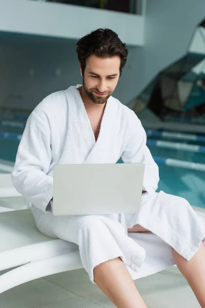 Young Man Bathrobe Earphone Using Laptop Spa Center — Stock Photo, Image