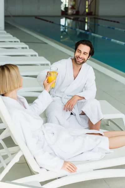 Smiling Man Clinking Orange Juice Girlfriend Deck Chair Spa Center — Stock Photo, Image