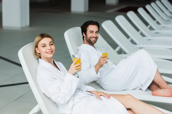 Young Woman Holding Orange Juice Blurred Boyfriend Deck Chair Spa — Stock Photo, Image