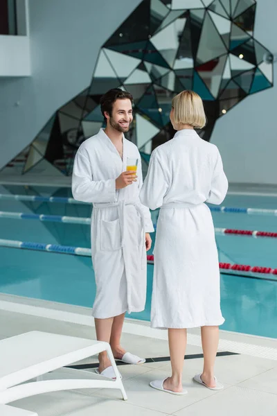 Cheerful Man Orange Juice Talking Girlfriend Spa Center — Stock Photo, Image