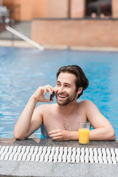 Glad Man Talar Smartphone Nära Apelsinjuice Poolen — Stockfoto
