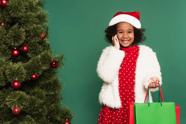 Vrolijk Afrikaans Amerikaans Meisje Santa Hoed Met Boodschappentassen Praten Smartphone — Stockfoto