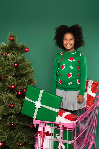 African American Girl Standing Shopping Cart Gifts Christmas Tree Isolated — Stock Photo, Image