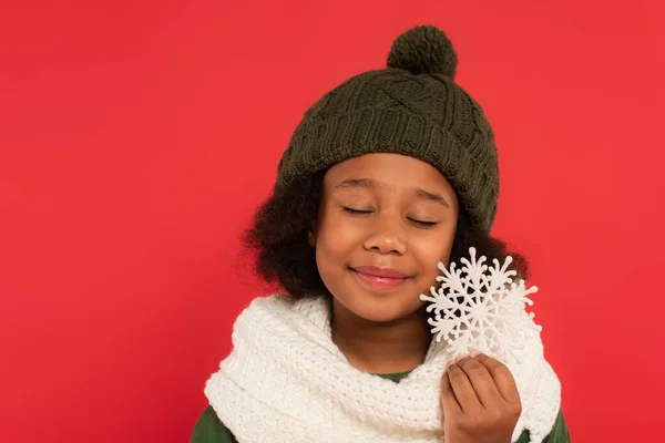 Afroamerikanerin Mit Hut Und Strickschal Hält Schneeflocke Auf Rot — Stockfoto