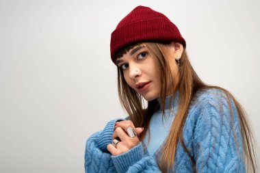 Genç bir kadın şık, sıcak kıyafetler içinde poz verir. Sonbahar için ışıl ışıl bir güzellik..