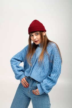 Genç bir kadın rahat sonbahar kıyafetlerini sergilerken arka planda güvenle poz veriyor..