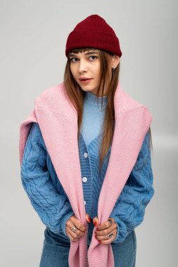 Genç bir kadın, yumuşak bir zemine şakayla poz verirken renkli katmanlar içinde sıcaklık saçıyor..