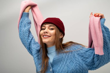 Parlak giyimli kadın, şık örgü tercihlerini sergilerken neşesini ve sıcaklığını ifade ediyor..