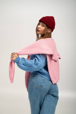 Genç bir kadın canlı sonbahar tarzını sergiliyor, rahat bir kıyafet giyiyor ve sıcak bir hava yayıyor..