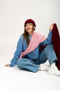 Güzel bir kadın, güz mevsiminin sıcacık havasını kutlamak için sıcak giysiler içinde poz verir..