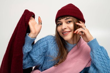 Güzel genç bir kadın kendine güvenerek poz verir, düşüşün özünü yansıtan kalın giysiler giyer..