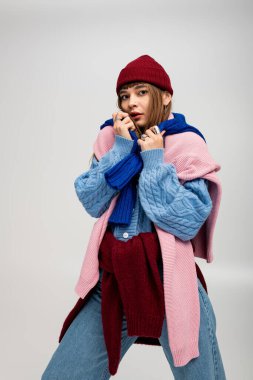 Güzel, genç bir kadın, rahat katlar içinde, neşeli bir sonbahar elbisesi içinde poz veriyor..