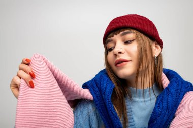 Güzel, genç bir kadın sıcak ve renkli kıyafetlerini sergileyerek sevinç ifade ediyor..