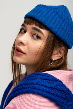 Güzel genç bir kadın, alımlı görünüşünü vurgulamak için, kalın giysiler içinde cazibe yayar..