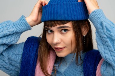 Güzel, genç bir kadın moda kıyafetlerini sergiliyor, serin mevsime sıcaklık katıyor..