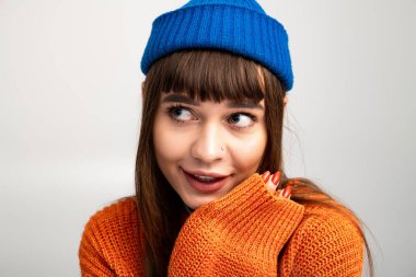 Parlak giyinmiş güzel genç bir kadın neşe içinde poz verirken canlı tarzını sergiliyor..