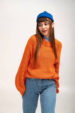 Güzel genç bir kadın şık bir sonbahar elbisesi içinde, mevsimsel tarzı kucaklayarak poz veriyor..