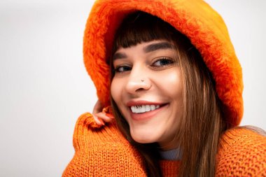 Güzel, genç bir kadın, sıcaklığını ve tarzını, rahat sonbahar kıyafetleriyle, neşeyle poz vererek sergiliyor..