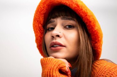 Güzel, genç bir kadın, güz boyunca kendine güveni ve tarzı olan, kalın giysiler içinde poz verir..