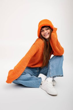 Güzel genç bir kadın, güz mevsimini kucaklayan, sıcak, şık giysiler içinde neşeli poz verir..