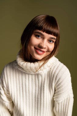 Şık bir süveter içinde güzel genç bir kadın, güler yüzle, sonbahar havasını ve neşesini gösterir..