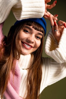 Hoş bir sonbahar elbisesi içinde poz verirken uzun saçlı hoş bir kadın sıcacık gülümsüyor..