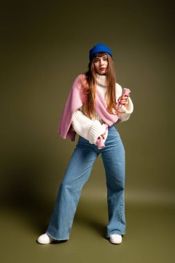 Bu güzel genç kadın şık kış kıyafetlerini oyuncu bir duruş ve tavırla sergiliyor..