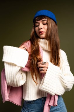 Genç bir kadın, canlı, samimi bir modaya sahip, sıcak bir arka plana karşı modellik yapıyor..