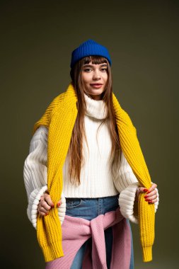 Güzel, genç bir kadın şık, sıcak bir şekilde poz verir. Kendine güven ve neşe saçar..