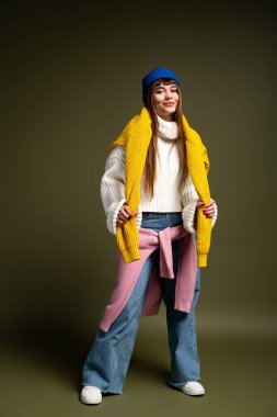 Güzel genç bir kadın, güz sıcaklığını somutlaştırırken şık tabakalarını neşeyle sergiliyor..