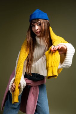 Güzel genç bir kadın şık bir sonbahar elbisesi içinde canlı renklerle poz verir..