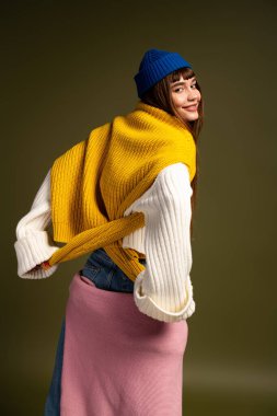 Genç bir kadın sıcak, katmanlı giysiler içinde serin sonbahar günleri için mükemmel poz verirken neşe saçıyor..