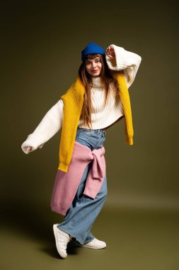 Parlak giyimli genç bir kadın, sonbaharın güzelliğinden, canlı pozlardan ve rahat kıyafetlerden hoşlanır..