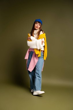 Genç bir kadın şık kıyafetini sergiliyor, bu sezon sıcaklık ve güven saçıyor..