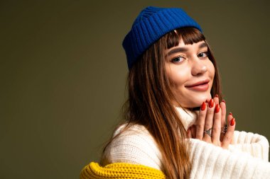 Hoş görünümlü genç bir kadın, neşeli ruhunu sıcak bir gülümseme ve şık bir pozla gösterir..