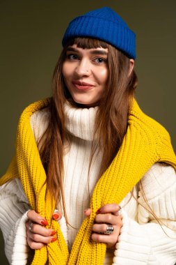 Genç bir kadın, sıcak katmanlara sarılı canlı sonbahar giysileri sergilerken neşe saçıyor..