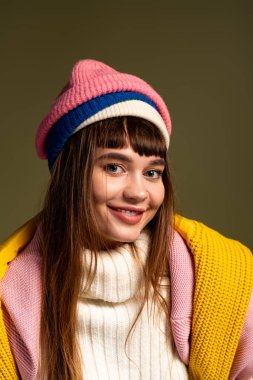 Şık genç bir kadın kışa ve sonbahara uygun rahat elbisesini sergileyerek ışıl ışıl gülümser..