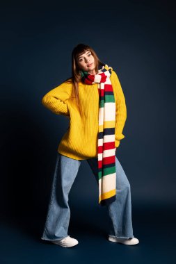 Güzel, genç bir kadın, güz havasını kucaklayan, kendine güvenen, şık kıyafetler içinde poz verir..